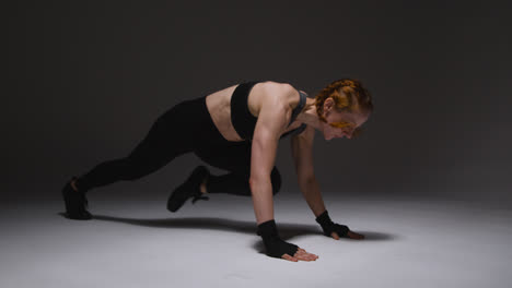 Studio-Shot-Of-Mature-Woman-Wearing-Gym-Fitness-Clothing-Doing-Mountain-Climber-Exercise-2